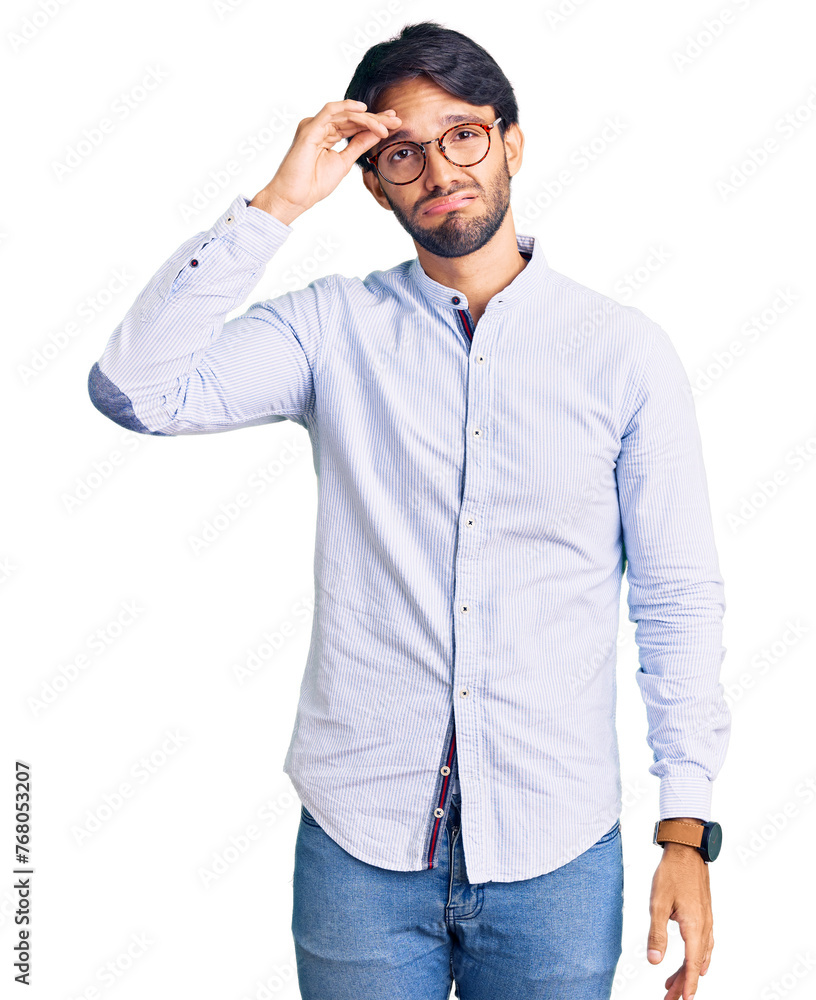 Handsome hispanic man wearing business shirt and glasses worried and stressed about a problem with hand on forehead, nervous and anxious for crisis Handsome hispanic man wearing business shirt and glasses worried and stressed about a problem with hand on forehead, nervous and anxious for crisis