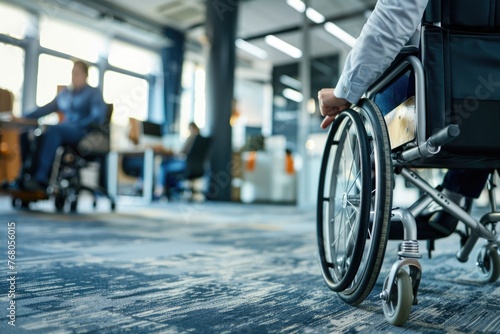 a businesswoman using a wheelchair moving through an office environment. The focus is on the wheelchair and the woman's hand as she propels herself forward