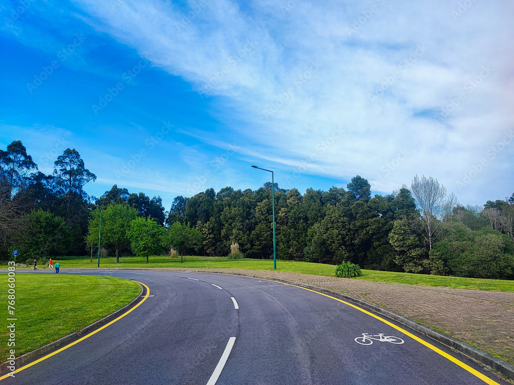empty bike path in a park with green trimmed grass empty bike path in a park with green trimmed grass