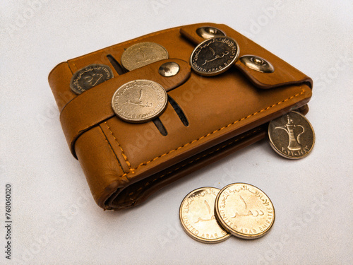 Brown wallet side view with UAE dirham coins currency 23 march 2024.