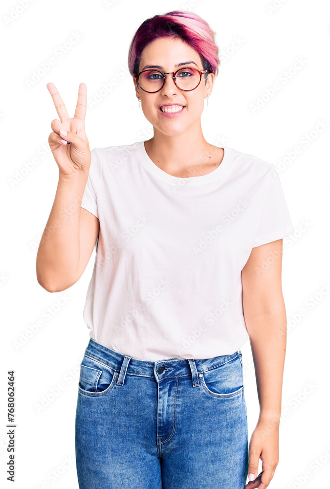 Young beautiful woman with pink hair wearing casual clothes and glasses showing and pointing up with fingers number two while smiling confident and happy. Young beautiful woman with pink hair wearing casual clothes and glasses showing and pointing up with fingers number two while smiling confident and happy.