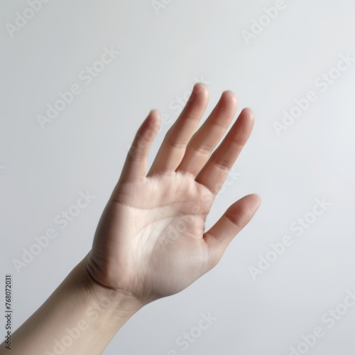 A human hand is raised against a plain background