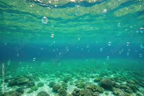 Bubbles and bokeh underwater in clear green ocean photo
