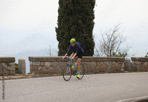cyclist with protective helmet pedals uphill on a racing bicycle during the cycling race in the mountains