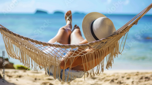Person Relaxing in a Hammock on a Tropical Beach with a Straw Hat