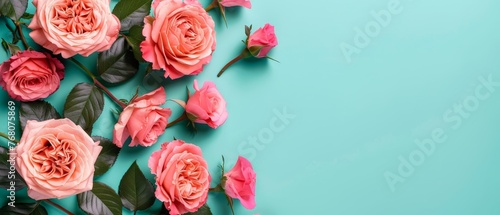   A blue backdrop adorned with a cluster of pink roses and lush green foliage, providing space for text or an image