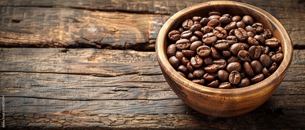 A bowl of coffee beans sits on a wooden table alongside driftwood A bowl of coffee beans sits on a wooden table alongside driftwood