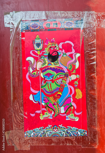 Red door with guardian poster in Menlou hutong in Beijing, China
