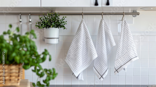 Fresh Kitchen Towels Hanging Neatly on Modern Rail. Pristine white kitchen details evoke cleanliness and order