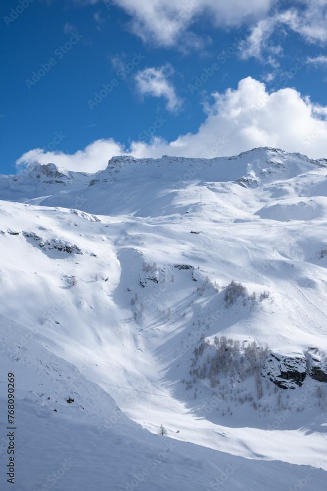 Mountain slopes covered in snow against a blue sky 