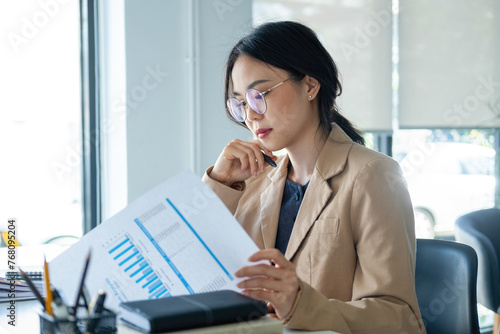 Businesswoman working on analyzing charts and graphs.