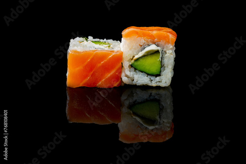 two pieces of sushi on a black background