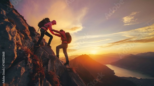 Friends helping each other hike up a mountain at sunrise. Giving a helping hand, and active fit lifestyle concept. © JW Studio
