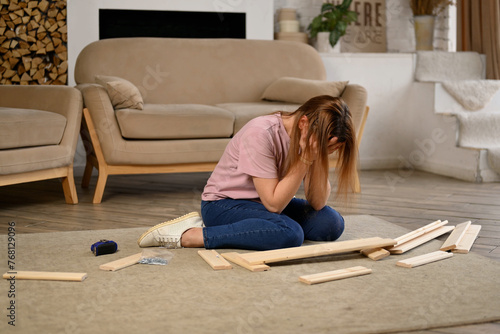 A woman is freaking out because she can t assemble a rack according to bad instructions the parts don t fit. Woman throws parts and instructions aside
