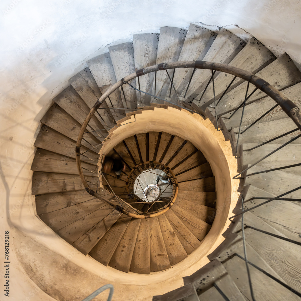 Fototapeta premium A captivating view of a descending spiral staircase, showcasing the architectural beauty and design, captured from the top angle