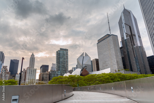 View of Chicago Loop skyline from a a deserted winding footbridge under cloudy sky at sunset