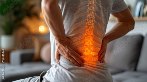 the back of a man touching his lower back pain, red zone. spinal disc disease, health problems concept.
