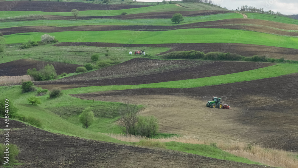 Tractor plowing the field on green hills, beautiful panorama landscape in countryside Tractor plowing the field on green hills, beautiful panorama landscape in countryside