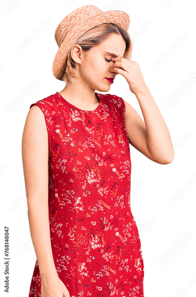 Young beautiful blonde woman wearing summer hat tired rubbing nose and eyes feeling fatigue and headache. stress and frustration concept. Young beautiful blonde woman wearing summer hat tired rubbing nose and eyes feeling fatigue and headache. stress and frustration concept.