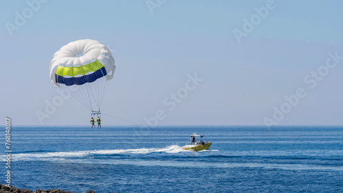 Speed boat on sea pull paraglide with tourists couple enjoy adventure