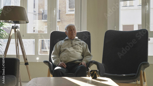 Single elderly man taking a nap in the armchair at home