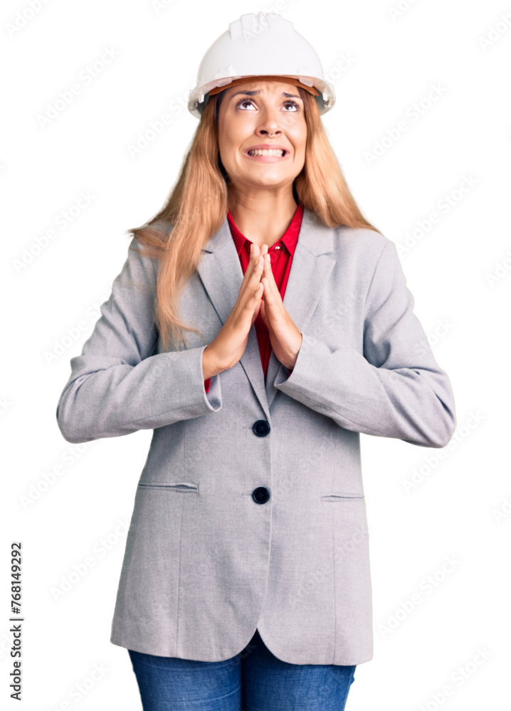 Beautiful young woman wearing architect hardhat begging and praying with hands together with hope expression on face very emotional and worried. begging. Beautiful young woman wearing architect hardhat begging and praying with hands together with hope expression on face very emotional and worried. begging.