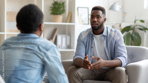 Amidst the soothing ambiance of the psychologist's office, a positive black man sits at ease, sharing his progress and achievements from therapy with a sense of empowerment.
