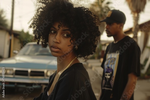 Cinematic shot, black woman in the foreground, black man in the background wearing street fashion clothing. Car and streets on a blurred background
