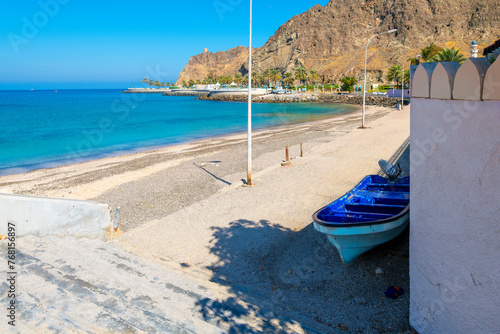 A small fishing boat on the sand along the Gulf of Oman and Muttrah Corniche at Kalbuh Bay and Park, Muscat, Oman. photo