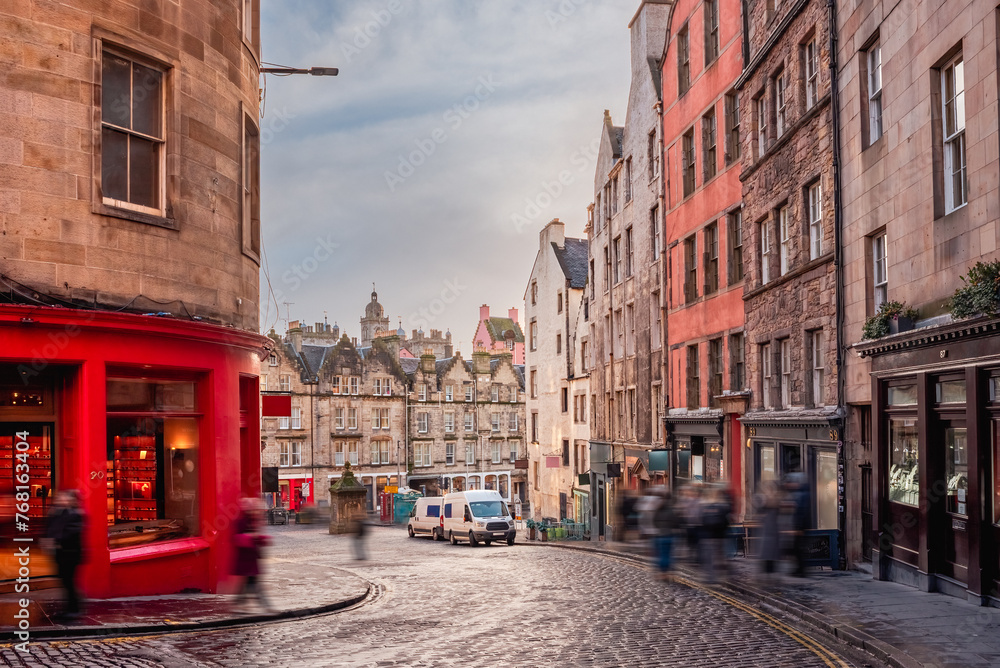 A bright red storefront and old buildings along West Bow and Victoria Street in Edinburgh Old Town, Scotland