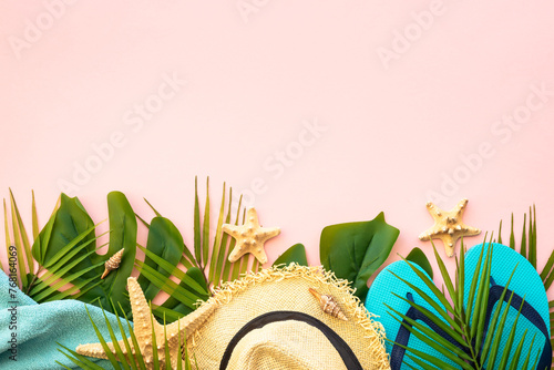 Summer flat lay background. Palm leaves, sea shells and summer cloth on pink background. © nadianb