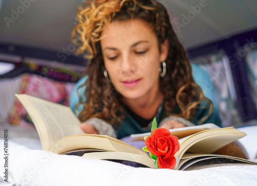 woman reading a book with a rose in Sant Jordi. Book festival in catalonia photo