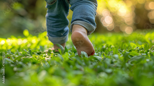 Niño paseando descalzo por la Hierba Fresca photo
