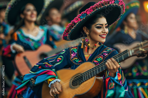 A woman in a colorful dress is playing a guitar in a parade. The other people in the parade are also playing instruments
