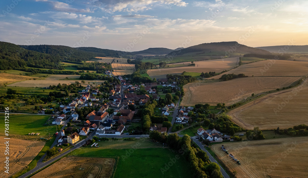 Aer ial view of a German village surrounded by meadows, farmland and forest. Germany.
