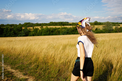 Young Woman Walking in Golden Wheat Field