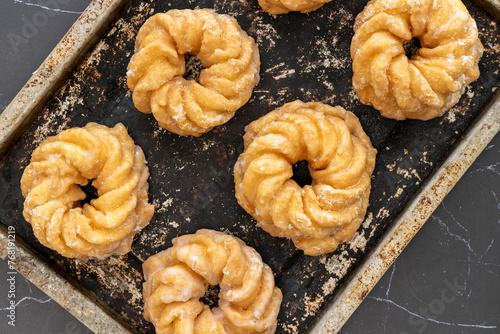 Honey cruller donuts on a baking tray