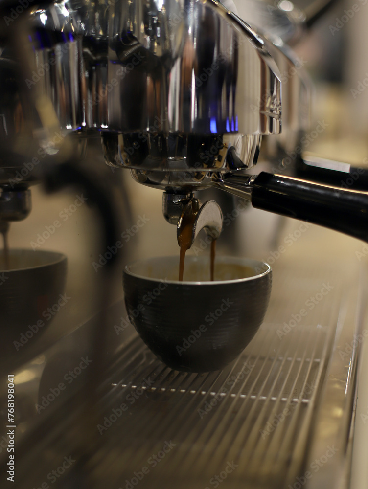 taza en la cafetera del restaurante llenándose de café para elaborar capuchino taza en la cafetera del restaurante llenándose de café para elaborar capuchino