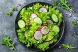 vegetables on a plate. vegan salad with vegetable ingredients: radish, fresh cucumber and lettuce leaves. spring food.