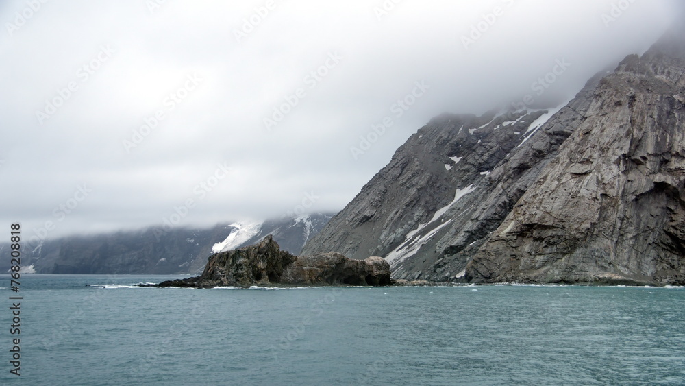 Rocky islet off a rugged coastline on Elephant Island, Antarctica Rocky islet off a rugged coastline on Elephant Island, Antarctica