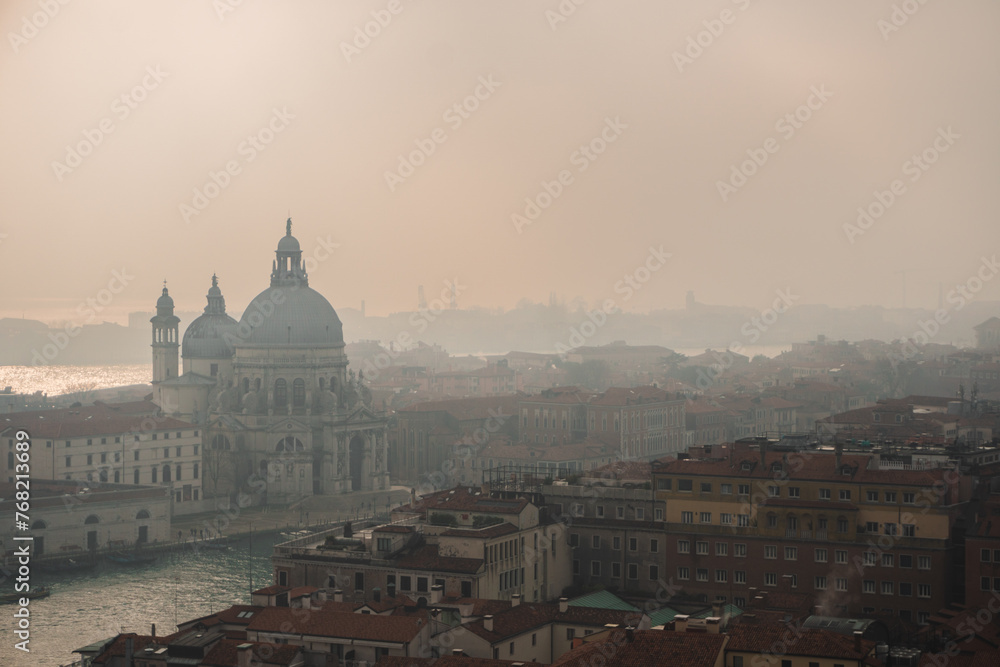 Misty day in Venice: View from San Marco Campanile captures Grand Canal, Basilica di Santa Maria della Salute, and foggy city skyline.