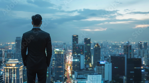 Businessman on rooftop overlooking city.