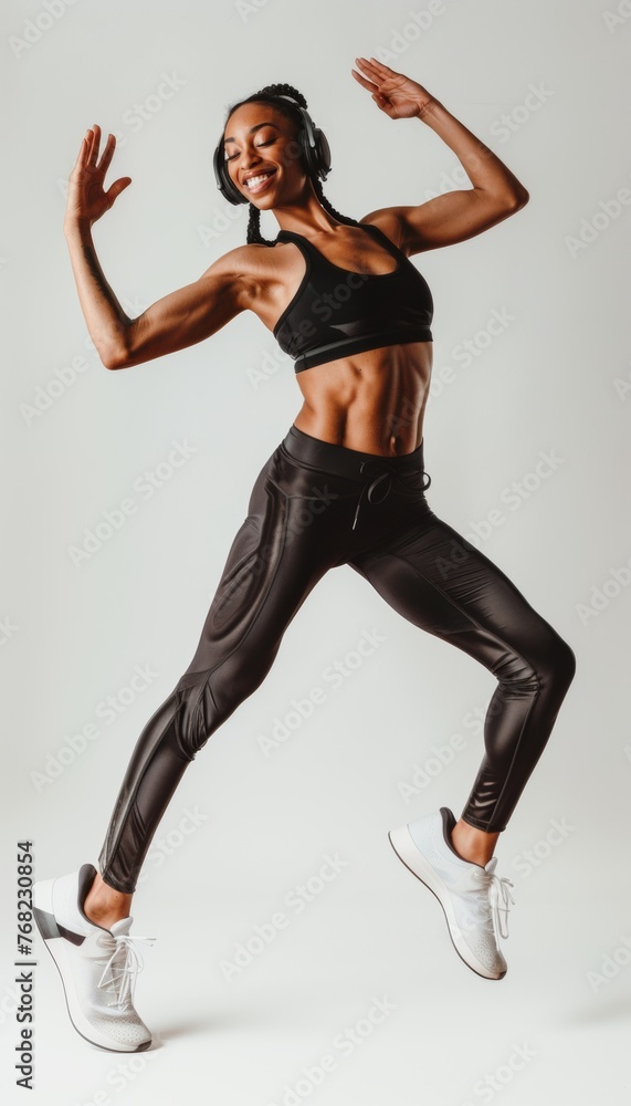 Young African American woman in sportswear and headphones smiles and listens to music. Active lifestyle.