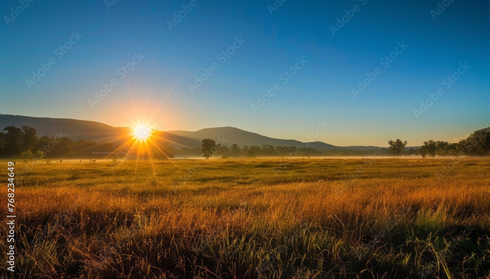 Sun Setting Over Grassy Field
