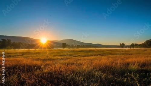 Sun Setting Over Grassy Field