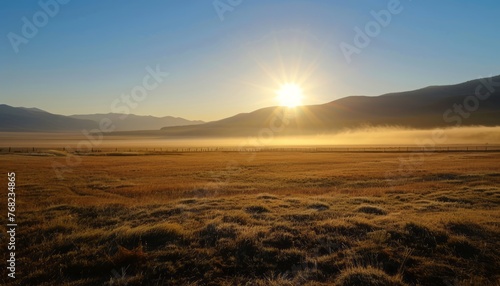Sun Setting Over Field With Mountains in Background © DigitalMuseCreations