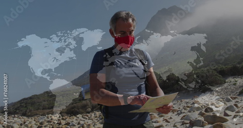 Caucasian senior man in face mask hiking reading map, over moving world map