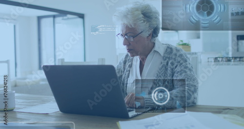 Image of data processing over senior african american businesswoman working on laptop in office