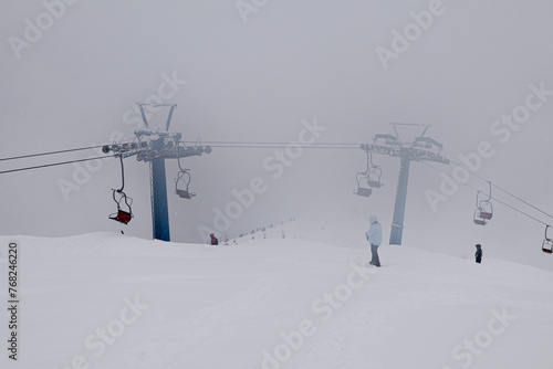 Dragobrat, Ukraine. March 18, 2024. In the morning, the village was heavily covered with snow. everything was covered in thick fog, but people continued to ski and climb the mountains on lifts.