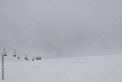 Dragobrat, Ukraine. March 18, 2024. In the morning, the village was heavily covered with snow. everything was covered in thick fog, but people continued to ski and climb the mountains on lifts.